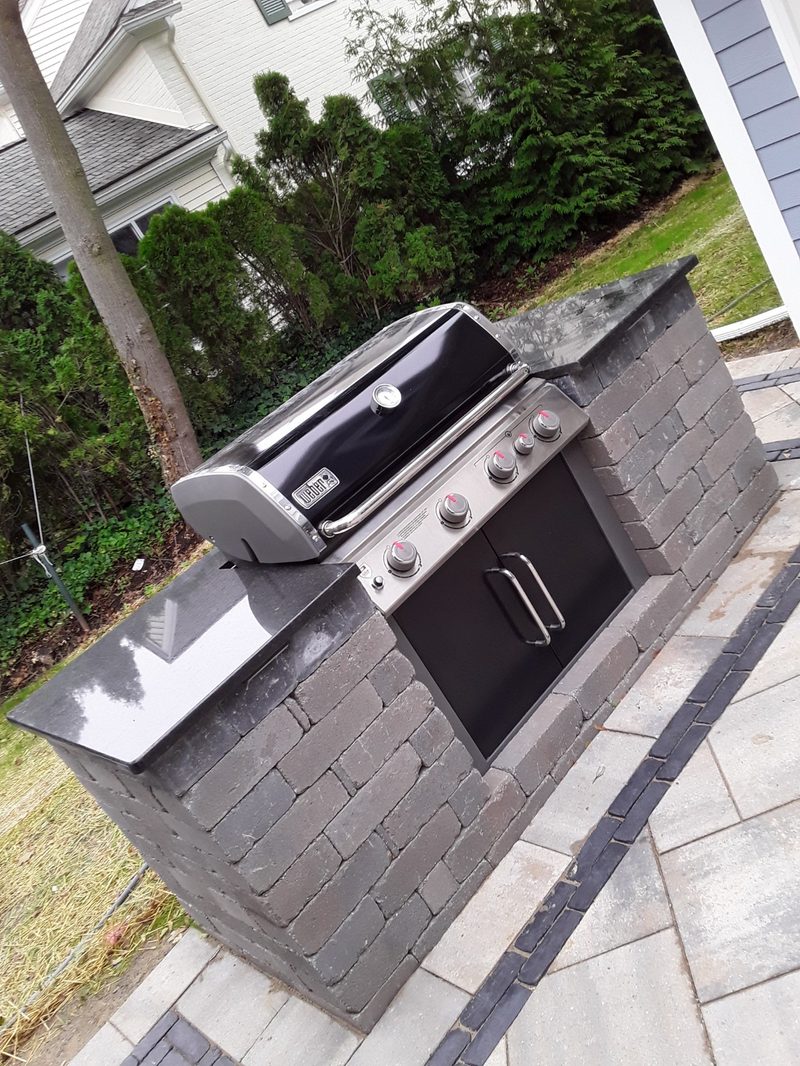 Built-in grill island with stone veneer