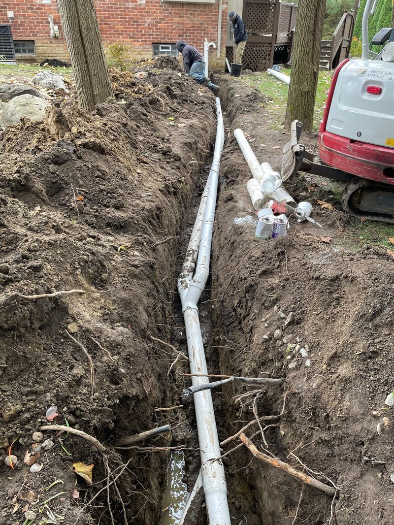 Drainage trench with PVC pipe and excavator