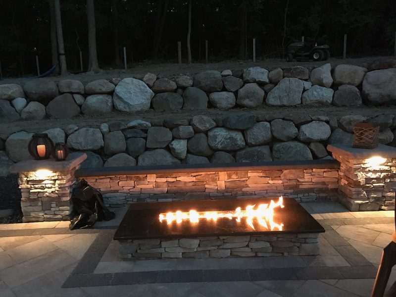 Linear fire feature with boulder wall at night
