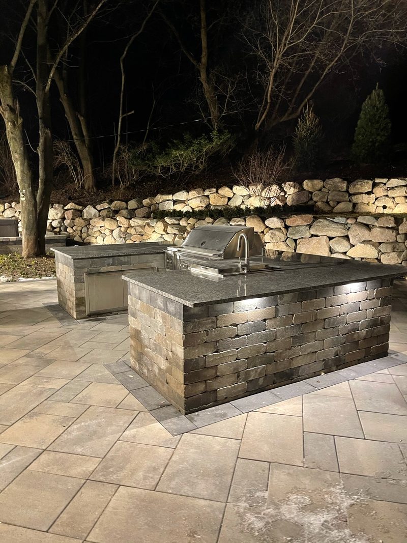 Outdoor kitchen with grill at night